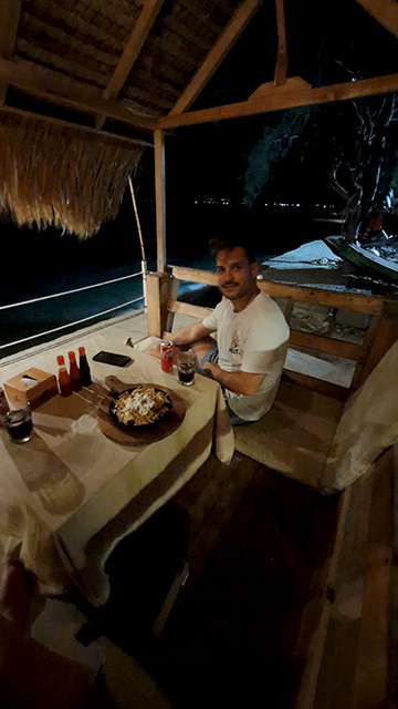 Hombre cenando orilla del mar en Gili Air