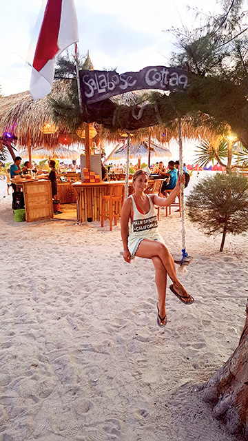 Mujer en columpio de chiringuito en Gili Air
