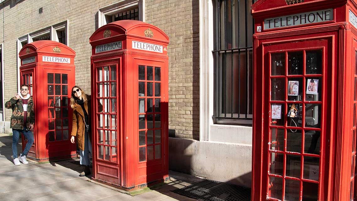 Pareja en 3 cabinas de teléfono rojas de Londres