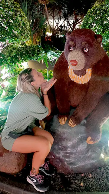 Mujer viendo un oso de peluche gigante